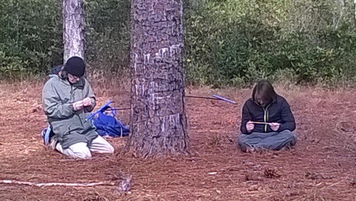 Dr. Knapp and Maxwell examining core samples they just obtained with increment borers (blue instrument) from a longleaf pine tree.